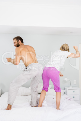 Young couple dancing on bed