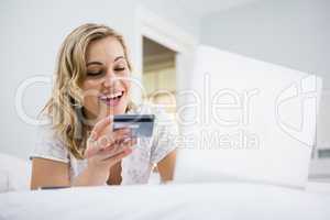 Woman shopping online on bed