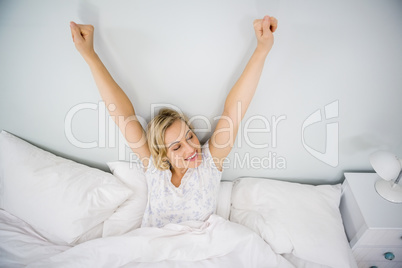 Woman stretching her arms in bed