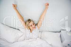 Woman stretching her arms in bed