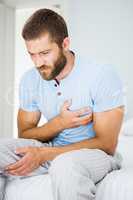 Young man having chest pain in bed