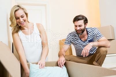 Young couple unpacking carton in their new house