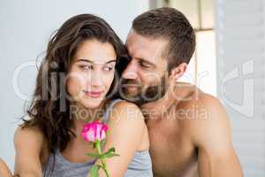 Man offering a rose to woman