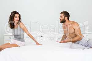 Man arguing with woman on bed