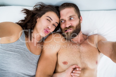 Couple making funny faces on bed