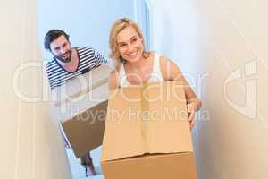 Couple holding a carton in their new house