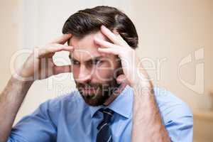 Close up of tensed man with hands on forehead