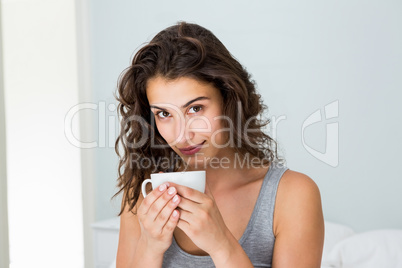 Close up of woman having coffee on bed