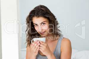 Close up of woman having coffee on bed