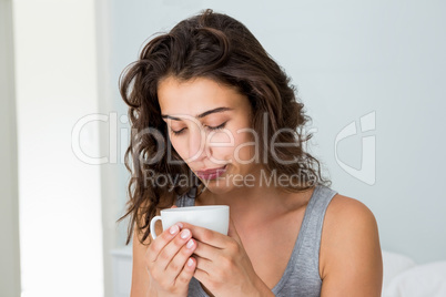 Close up of woman having coffee on bed