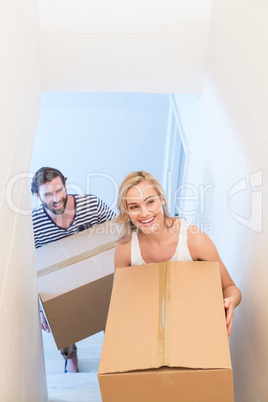Couple holding a carton in their new house