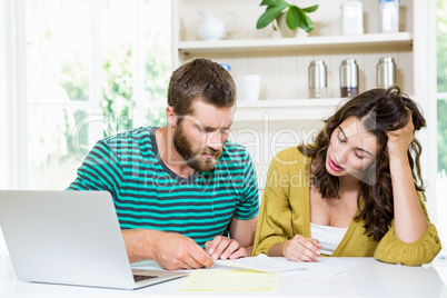 Couple checking their bills in kitchen