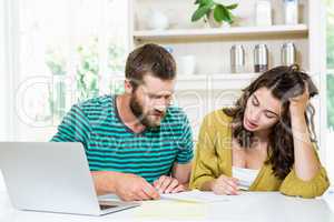 Couple checking their bills in kitchen