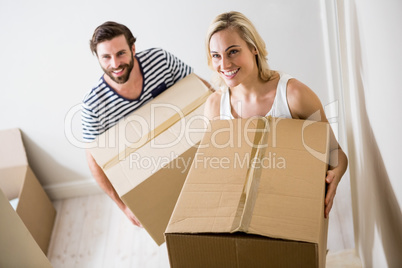 Couple holding a carton in their new house