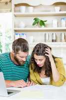 Couple checking their bills in kitchen