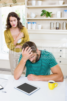 Woman looking a upset man in kitchen