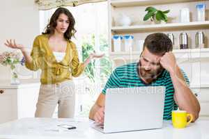 Woman arguing with upset man in kitchen