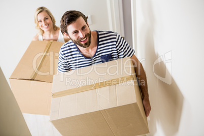 Couple holding a carton in their new house