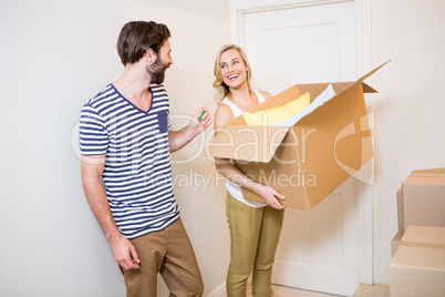 Couple holding a carton in their new house