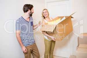 Couple holding a carton in their new house