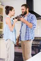 Young couple holding wine glass in kitchen
