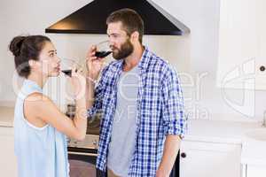Young couple having red wine in kitchen