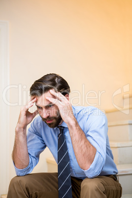 Worried man sitting on stairs