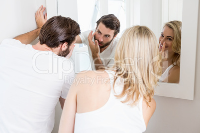 Young couple applying cream on the face