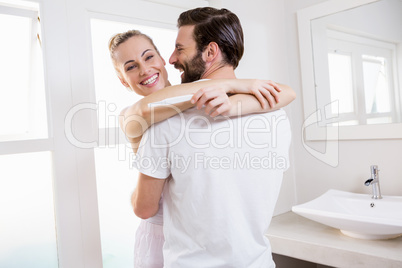 Woman looking at pregnancy test while embracing a man