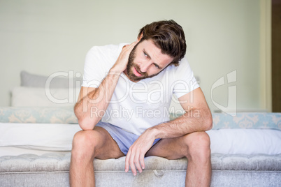 Worried man sitting on bed