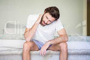 Worried man sitting on bed