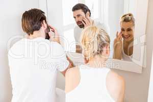 Couple checking their skin in bathroom