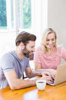 Happy young couple using laptop