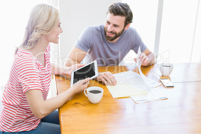 Couple looking at each other while using digital tablet