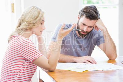 Worried young couple checking on bills