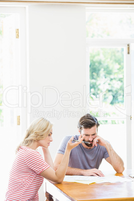 Worried young couple checking on bills