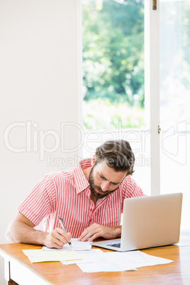 Young man calculating his bills