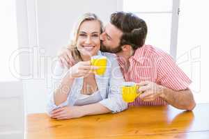 Man kissing woman while having coffee