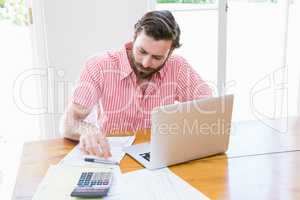 Young man calculating his bills