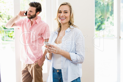 Woman texting messaging while man talking on mobile phone