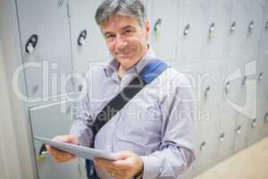 Portrait of professor using digital tablet in locker room