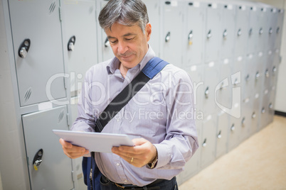Professor using digital tablet in locker room