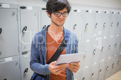 Student using digital tablet in locker room