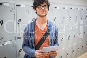 Portrait of student using digital tablet in locker room