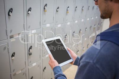 Student using digital tablet in locker room