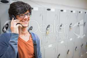 Happy student talking on phone in locker room