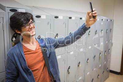 Smiling student taking selfie in locker room