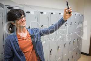 Smiling student taking selfie in locker room