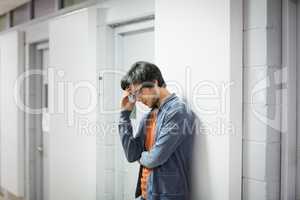 Worried student leaning on wall