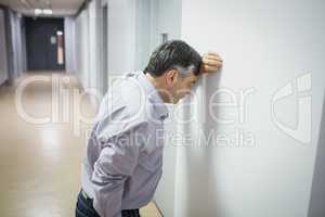 Worried professor leaning on wall